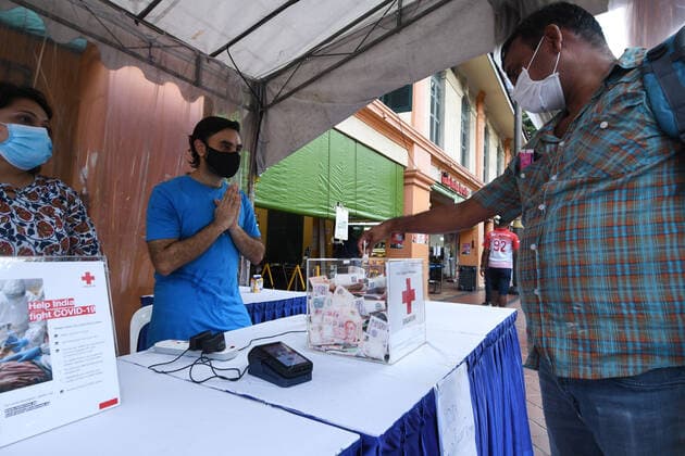 (210506) -- SINGAPORE, May 6, 2021 -- A man donates money at a Singapore Red Cross (SRC) fundraising booth in Singapore s Little India, on May 6, 2021. The event is part of the SRC s relief effort to help India fight against the COVID-19 pandemic. (Photo by Xinhua) SINGAPORE-RED CROSS-COVID-19-FUNDRAISING FOR INDIA ThenxChihxWey 