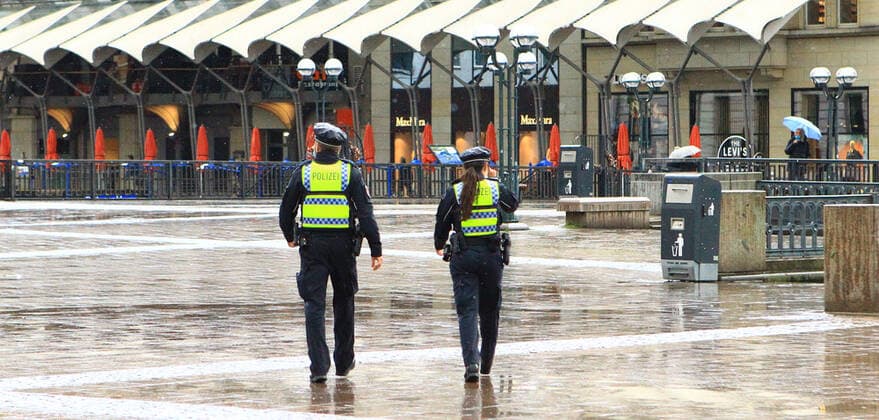 Polizisten gehen während eines Regenschauers über den Hamburger Rathausmarkt. Altstadt Hamburg