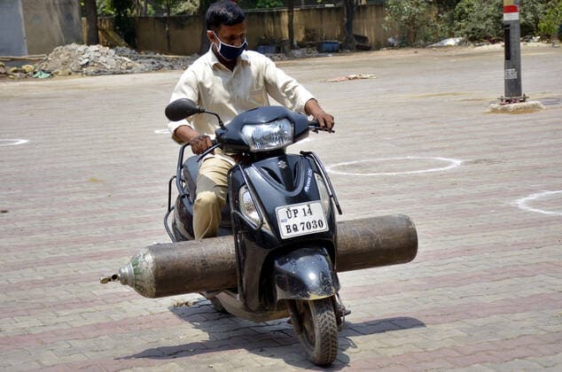 GHAZIABAD, INDIA - MAY 6: A person leaving with an oxygen cylinder made available by the Municipal Corporation at Nehru Nagar on May 6, 2021 in Ghaziabad, India. (Photo by Sakib Ali Hindustan Times) India Faces Oxygen Crisis As Covid-19 Cases Mount