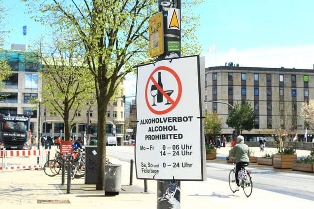 An einem Pfahl am Jungfernstieg in der Hamburger Innenstadt hängt ein Schild, das darauf hinweist, dass in diesem Bereich zu bestimmten Zeiten Alkoholverbot besteht. Altstadt Hamburg