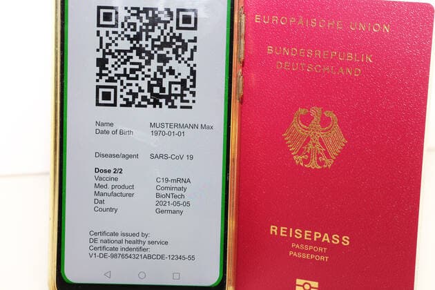 Symbolbild: Reisepass und ein digitaler Grüner Pass als Nachweis einer Impfung