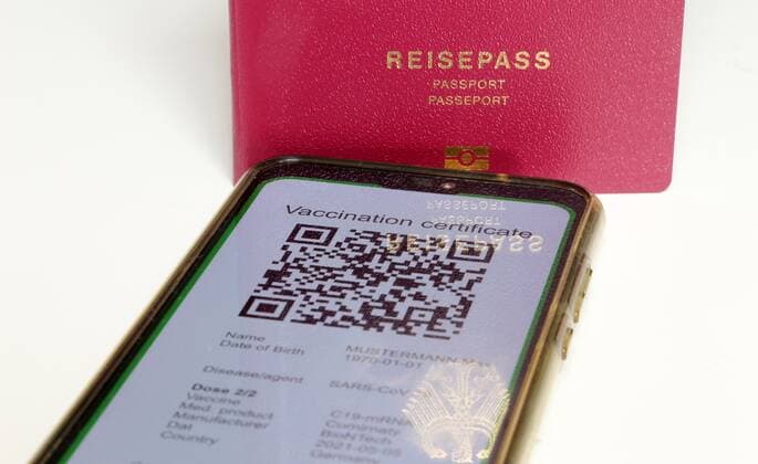 Symbolbild: Reisepass und ein digitaler Grüner Pass als Nachweis einer Impfung