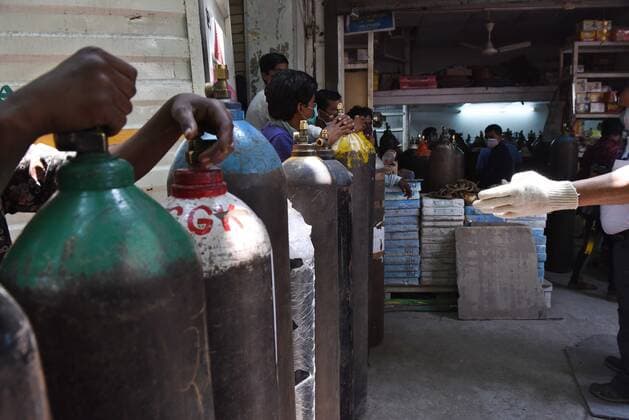 NEW DELHI, INDIA - MAY 7: Peope at an oxygen cylinder refilling centre at Bhogal on May 7, 2021 in New Delhi, India. (Photo by Ajay Aggarwal Hindustan Times) India Faces Oxygen Crisis As Covid-19 Cases Mount