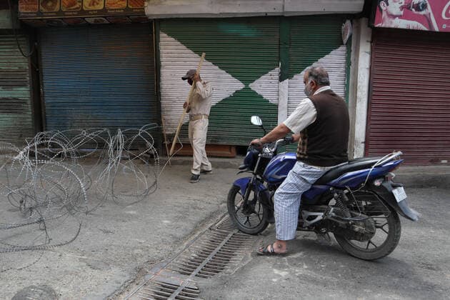 Covid-19: Strict Lockdown In Kashmir An Indian policeman stop civilian traffic outside Kashmir s grand mosque during Covid-19 lockdown on the last friday of Ramadan in Srinagar, Indian Administered Kashmir on 07 May 2021. Thousands of people attend the prayers on the normal days every year due to covid-19 all the major mosques were closed. Srinagar India mattoo-notitle210507_npxGe  Copyright: xMuzamilxMattoox