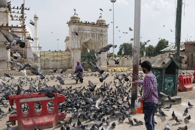 Covid-19: Strict Lockdown In Kashmir A boy feeds pigeons outside deserted Hazratbal mosque during Covid-19 lockdown on the last friday of Ramadan in Srinagar, Indian Administered Kashmir on 07 May 2021. Thousands of people attend the prayers on the normal days every year due to covid-19 all the major mosques were closed. Srinagar India mattoo-notitle210507_np3rI  Copyright: xMuzamilxMattoox