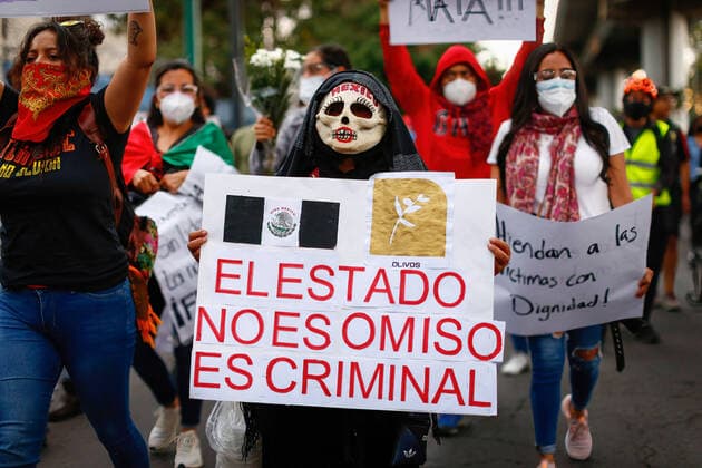May 7, 2021, Mexico City, Mexico: A protester wearing a mask carries a sign that reads The state is not disregard it is criminal during a protest march in Tlahuac Mayoralty..Protesters take to the streets of Mexico city demanding justice for those involved in the subway overpass incident that collapsed and has killed 25 people so far. Mexico City Mexico - ZUMAs197 20210507_zaa_s197_168 Copyright: xGuillermoxDiazx