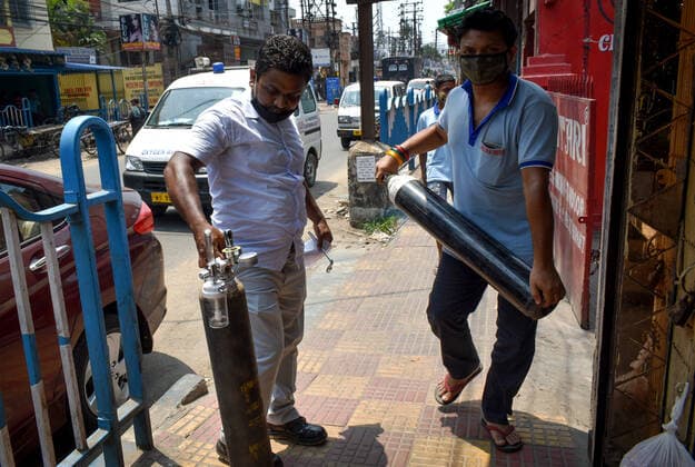 India: The oxygen crisis still continues in Kolkata Family members of Covid-19 infected patients are carrying an oxygen cylinder during the oxygen crisis situation, amid the spread of Corona virus (Covid-19) in Kolkata. Kolkata West Bengal India Copyright: SudiptaxDas