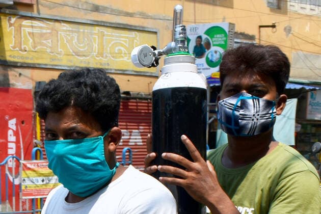 India: The oxygen crisis still continues in Kolkata Family members of Covid-19 infected patients are carrying an oxygen cylinder during the oxygen crisis situation, amid the spread of Corona virus (Covid-19) in Kolkata. Kolkata West Bengal India Copyright: SudiptaxDas