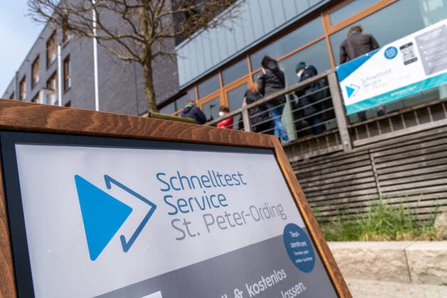 Hinweisschild und Warteschlange vor Testzentrum - Schnelltest Service - Modellregion St. Peter-Ording in Schleswig-Holstein an der Nordsee ;Hinweisschild und Warteschlange vor Testzentrum - Schnelltest Service - Modellregion St. Peter-Ording in Schleswig-Holstein an der Nordsee , Sankt Peter-Ording Schleswig-Holstein Deutschland Ording