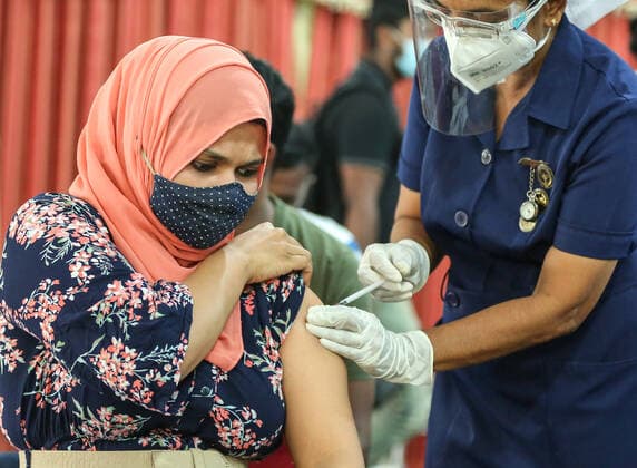 Sri Lanka: First dose of the Chinese-made Sinopharm COVID-19 vaccine A health worker inoculates a woman with a dose of the Chinese-made Sinopharm Covid-19 coronavirus vaccine in Sri Lanka Colombo on May 9, 2021. Colombo Sri Lanka Copyright: SamanxAbesiriwardana