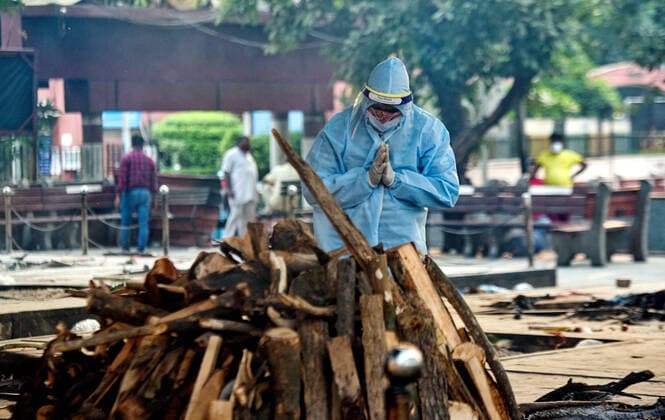 NEW DELHI, INDIA - MAY 9: A relative of a Covid-19 victim performs the last rites, at Nigambodh Ghat crematorium, on May 9, 2021 in New Delhi, India. (Photo by Amal KS Hindustan Times ) Daily Life Amid Coronavirus Pandemic In India
