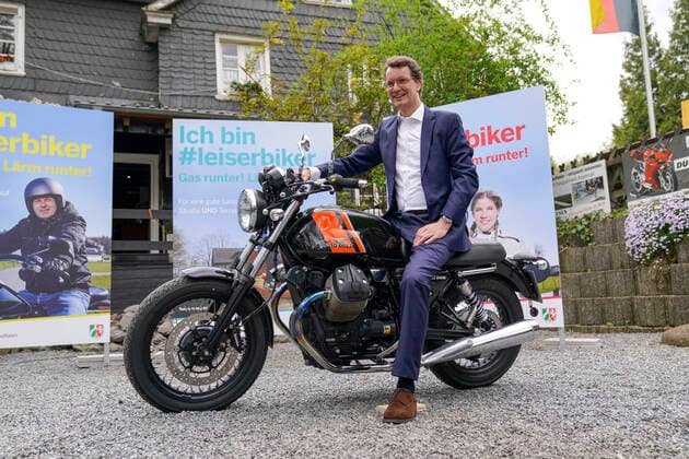 Verkehrsminister von NRW stellt die Landesinitiative leiserBiker in Solingen vor Aktuell, 10.05.2021, Solingen, Verkehrsminister von Nordrhein-Westfalen Hendrik Wuest auf einem Motorrad vor der Plakatwand der Landesinitiative Ich bin leiserBiker. Gas runter! Laerm runter! im Biker-Treff Cafe Hubraum in Solingen vor. Hierbei wurde von den Pressevertretern vor Ort auch die Frage bezueglich der Besetzung des Amtes als Ministerpraesident von Nordrhein-Westfalen gestellt. Solingen Nordrhein-Westfalen Deutschland *** Minister of Transport of North Rhine-Westphalia presents the state initiative leiserBiker in Solingen Current, 10 05 2021, Solingen, Minister of Transport of North Rhine-Westphalia Hendrik Wuest on a motorcycle in front of the po