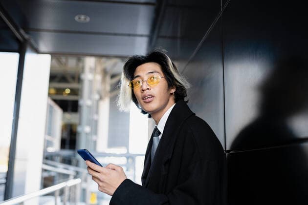 IMAGO Creative: 2021 Favoriten IMAGO Creative: Clickbait, Modetrends IMAGO Creative: Kreative Renaissance -- der junge Entrepreneur Young attentive Asian male executive in formal apparel and sunglasses text messaging o looking away Copyright: xJosexCarlosxCerdenox Model Released
