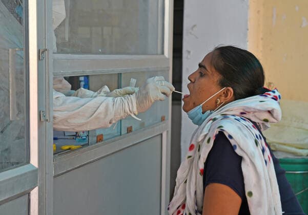 India: COVID-19 tests amid Pandemic in Rajasthan A health worker collects swab sample from a young woman at a COVID-19 testing lab during second wave of coronavirus epidemic, in Beawar. The health ministry on Monday reported 366,161 new infections and 3,754 deaths. India’s tally of infections now stands at 22.66 million, with 246,116 deaths. 80 doctors at Delhi s Saroj Hospital tested positive for coronavirus. Beawar Rajasthan India Copyright: SumitxSaraswat