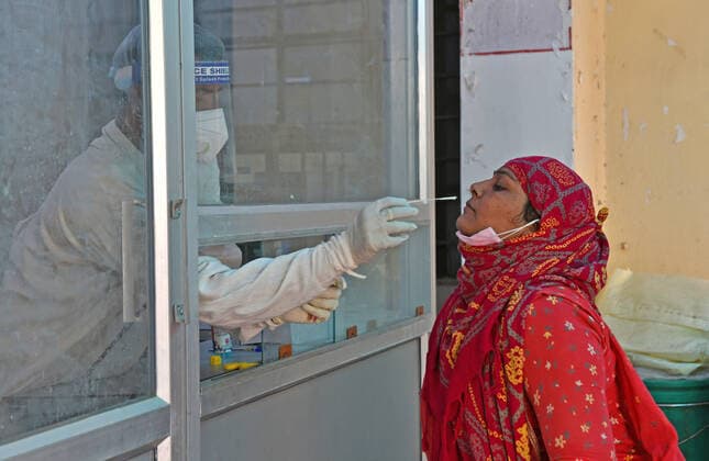 India: COVID-19 tests amid Pandemic in Rajasthan Beawar, Rajasthan, India, May 10, 2021: A health worker collects swab sample from a village woman at a COVID-19 testing lab during second wave of coronavirus epidemic, in Beawar. The health ministry on Monday reported 366,161 new infections and 3,754 deaths. India’s tally of infections now stands at 22.66 million, with 246,116 deaths. 80 doctors at Delhi s Saroj Hospital tested positive for coronavirus. Beawar Rajasthan India Copyright: SumitxSaraswat