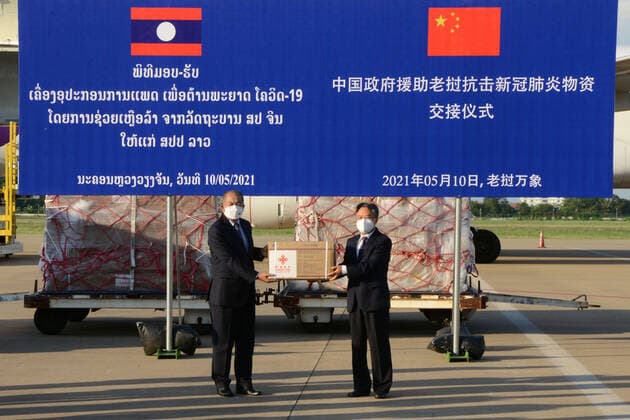 (210511) -- VIENTIANE, May 11, 2021 -- Chinese Ambassador to Laos Jiang Zaidong (R) and Lao People s Revolutionary Party (LPRP) central committee politburo member, Deputy Prime Minister and Chairman of the National Taskforce Committee for COVID-19 Prevention and Control Kikeo Khaykhamphithoune attend the handover ceremony of anti-epidemic material supplies donated by the Chinese government at Wattay International Airport in Vientiane, Laos, May 10, 2021. The Chinese government-donated anti-COVID-19 material supplies have arrived at Wattay International Airport in Lao capital Vientiane with a handover ceremony held upon their arrival. The Chinese government s emergency assistance to Laos includes ventilators, automatic nucleic acid extr 