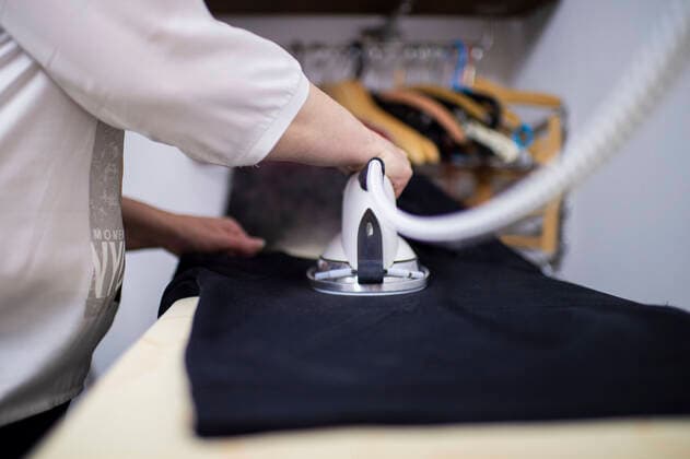 IMAGO Creative: Haushaltsgeräte, Bügeleisen Feature Büroarbeit Eine Frau bügelt Anziehsachen. Foto: Kirchner-Media Wedel Nordrhein-Westfalen Deutschland *** Feature Office Work A Woman Ironing Clothes Photo Kirchner Media Wedel North Rhine Westphalia Germany Copyright: xKirchner-Media Wedelx