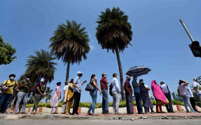 MUMBAI, INDIA - MAY 11: Beneficiaries wait in a queue in scorching heat outside BKC Jumbo Covid-19 Vaccination Centre to get vaccinated, on May 11, 2021 in Mumbai, India. (Photo by Satish Bate Hindustan Times ) COVID-19 Vaccination Drive