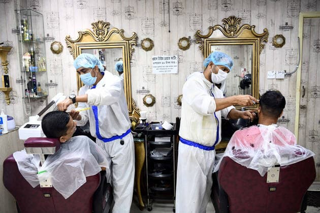 May 12, 2021, Dhaka, Bangladesh: Barbers wearing personal protective equipment (PPE) as a preventive measure against the spread of COVID19 attend to their salon clients in Dhaka. Dhaka Bangladesh - ZUMAs197 20210512_zaa_s197_068 Copyright: xPiyasxBiswasx