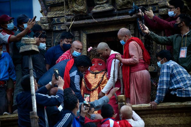 Longest Festival Rato Machindranath Begins During Prohibitory Lockdown In Kathmandu Valley Nepalese Priest carrying idol Rato Machindranath towards the chariot on the first day of the longest chariot festival of Nepal during prohibitory lockdown of covid pandemic in Lalitpur, Nepal on Wednesday, May 12, 2021. Rato Machindranath is also said as the God of Rain and both Hindus and Buddhists worship the Machindranath in hope of good rain to prevent drought during the rice plantation season. Lalitpur NP Nepal maharjan-longestf210512_npVmk  Copyright: xNarayanxMaharjanx