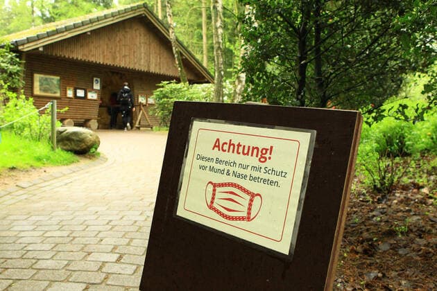 Im Wildpark Schwarze Berge im niedersächsischen Rosengarten weist ein Schild Besucher darauf hin, dass in diesem Bereich des Parks Maskepflicht besteht. Rosengarten Niedersachsen