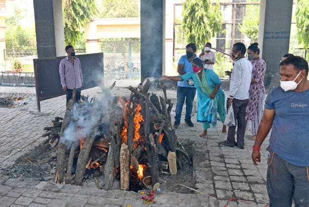 Cremation Of COVID-19 Victims In Rajasthan, India Relatives perform last rites during cremation of an old woman at Hindu Crematorium, amid coronavirus pandemic in Beawar. Beawar Rajasthan India Copyright: SumitxSaraswat