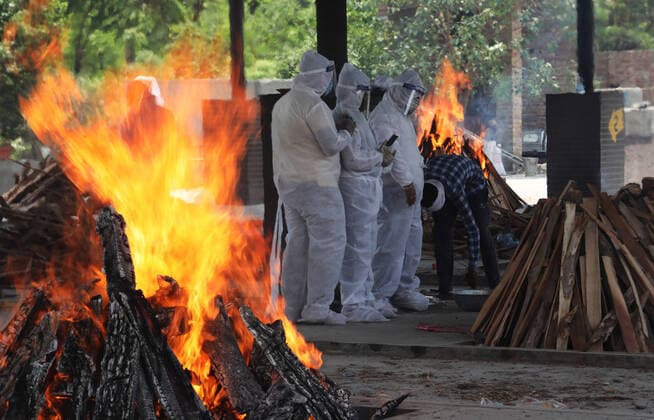 May 14, 2021, New Delhi, India: Relatives of coronavirus (Covid-19) victims perform the last rites during a cremation at Mangolpuri crematorium ground in New Delhi..India has recorded 343,144 people testing Covid-19 positive cases and 4,033 fatalities due to coronavirus infection in the last 24 hours according to the data released by Union Health Ministry on Friday. Across the country the cumulative death toll now stands at 262,317 while 20,079,599 people have recovered from the virus in the country. New Delhi India - ZUMAs197 20210514_zaa_s197_080 Copyright: xNaveenxSharmax