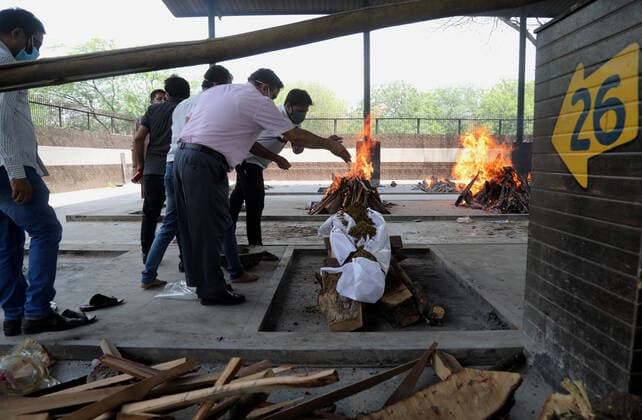 May 14, 2021, New Delhi, India: (EDITORS NOTE: Image depicts death).Relatives of a coronavirus (Covid-19) victim perform the last rites during a cremation at Mangolpuri crematorium ground in New Delhi..India has recorded 343,144 people testing Covid-19 positive cases and 4,033 fatalities due to coronavirus infection in the last 24 hours according to the data released by Union Health Ministry on Friday. Across the country the cumulative death toll now stands at 262,317 while 20,079,599 people have recovered from the virus in the country. New Delhi India - ZUMAs197 20210514_zaa_s197_089 Copyright: xNaveenxSharmax