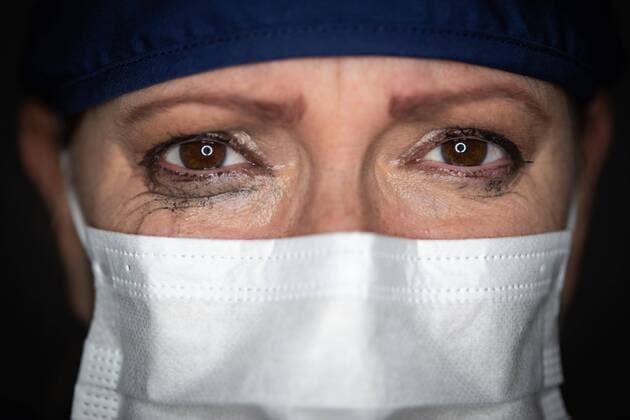 Tearful gestressten Ärztin oder Krankenschwester trägt medizinische Gesichtsmaske auf dunklem Hintergrund *** Tearful stressed doctor or nurse wearing medical face mask on dark background Copyright: imageBROKER/AndyxDean ibxdea06727515.jpg