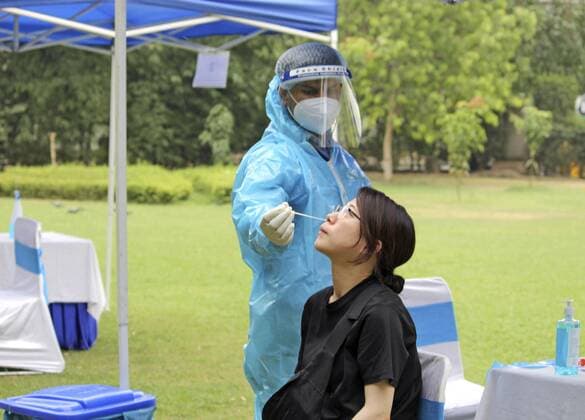 PCR center in India for returning Japanese nationals A Japanese woman takes a PCR test on May 17, 2021, at an outdoor facility set up at a hotel in the New Delhi suburbs for Japanese nationals returning home from the coronavirus-rampant India. 