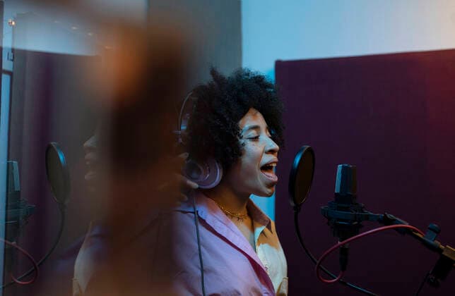 IMAGO Creative: 2021 Favoriten IMAGO Creative: Kreative Renaissance -- der junge Entrepreneur Black female singer performing song against microphone with pop filter while standing and looking forward in sound studio Copyright: xJosexCarlosxCerdenox Model Released