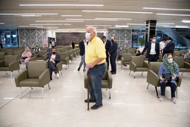 Iran: Vaccination of People over 75 years Iranian elderly people wearing protective face masks sit in a hall while waiting to receive a dose of the new coronavirus disease (COVID-19) vaccine in Iranmall shopping complex in northwest of Tehran. Tehran Iran Iranmall Copyright: SobhanxFarajvan