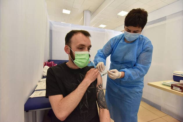 May 17, 2021, Lviv, Ukraine: A healthy worker injects a dose of AstraZeneca Covid-19 vaccine to a man at a vaccination center..The city of Lviv in western Ukraine is offering the IT industry workers to be vaccinated with the AstraZeneca Covid-19 vaccine at a vaccination center located at the Arena Lviv stadium. Lviv Ukraine - ZUMAs197 20210517_zaa_s197_330 Copyright: xPavloxPalamarchukx