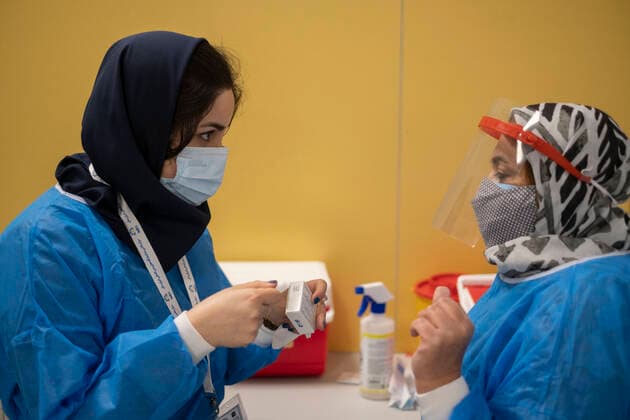 Virus Outbreak Iran Two Iranian medical personnel wearing protective suits talk to each other as one of them holds a box of the China s Sinopharm new coronavirus disease (COVID-19) vaccine, as they stand at the main vaccination hall in the Iran Grand Bazaar, Iran Mall, on day-3 of the mass general COVID-19 vaccination in western Tehran on May 17, 2021. Tehran Tehran Iran nikoubazl-day3ofma210517_npaG3  Copyright: xMortezaxNikoubazlx