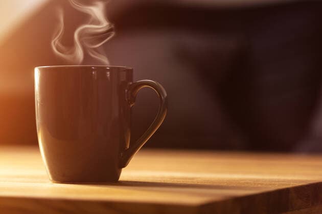 03 november 2020: gray cup of coffee on brown wooden table. morning sunshine. coffee for breakfast. hot coffee.