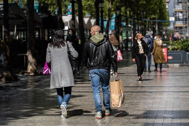 (210519) -- PARIS, May 19, 2021 -- People carrying shopping bags walk on the Champs Elysees Avenue in Paris, France, on May 19, 2021. France on Wednesday took an important step forward toward returning to normality as people in the country can once again meet up in cafes or enjoy a meal in restaurants, which are now allowed to open their terraces. Under the government s current plan to gradually relax the confinement measures, a maximum of six people per table are now allowed to be served on restaurant and cafe terraces. Museums, theaters, cinemas and sports facilities can now reopen to a maximum of 800 people indoors and 1,000 outdoors. (Photo by Xinhua) FRANCE-PARIS-COVID-19-REOPENING AurelienxMorissard 
