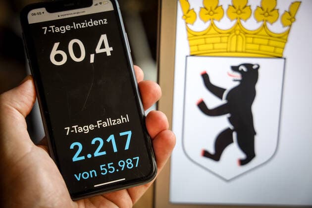 Coronavirus in Deutschland - Covid-19-Dashboard des Robert Koch-Institut DEU, Deutschland, Berlin, 21.05.2021: Die 7-Tage-Inzidenz für das Bundesland (Fälle letzte 7 Tage 100.000 EW) wird auf einem iPhone angezeigt, im Hintergrund das Landeswappen