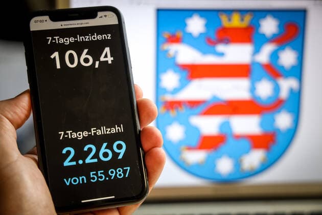 Coronavirus in Deutschland - Covid-19-Dashboard des Robert Koch-Institut DEU, Deutschland, Thüringen, 21.05.2021: Die 7-Tage-Inzidenz für das Bundesland (Fälle letzte 7 Tage 100.000 EW) wird auf einem iPhone angezeigt, im Hintergrund das Landeswappen