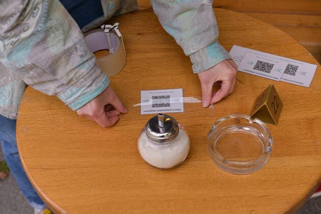 Berlin, Deutschland 21. Mai 2021: In Berlin darf die Aussengastronomie nach dem Lockdown zur Bekämpfung der Corona-Pandemie wieder öffne. Eine Person klebt QR-Codes für die Anwesenheitsliste auf die Tische des Lokals. Berlin Copyright: xFotostandx xReuhlx