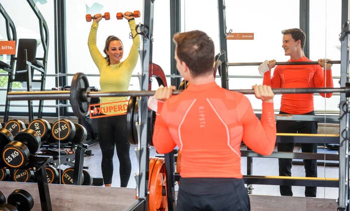 Essen, Nordrhein-Westfalen, Deutschland - Fitnesstraining in Zeiten der Corona Pandemie, Veronika und John freuen sich nach dem langen Lockdown bei ihrer ersten Trainingseinheit im FitX Fitnessstudio, die Stadt Essen und FitX setzen mit wissenschaftlicher Unterstuetzung des Universitaetsklinikums Essen ein Modellprojekt zum sicheren Trainingsbetrieb im Fitnessstudio um, mit innovativer Steuerung der Lueftungsanlagen und Umsetzung der Abstands-, Hygiene- und Arbeitsschutzmaßnahmen, beim Geraetetraining darf die Maske abgenommen werden. Essen Nordrhein-Westfalen Deutschland
