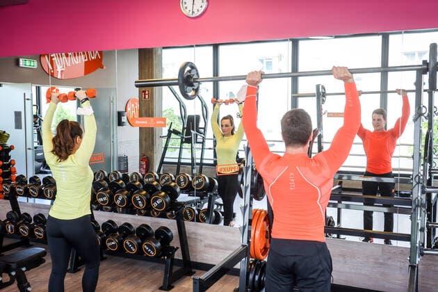 Essen, Nordrhein-Westfalen, Deutschland - Fitnesstraining in Zeiten der Corona Pandemie, Veronika und John freuen sich nach dem langen Lockdown bei ihrer ersten Trainingseinheit im FitX Fitnessstudio, die Stadt Essen und FitX setzen mit wissenschaftlicher Unterstuetzung des Universitaetsklinikums Essen ein Modellprojekt zum sicheren Trainingsbetrieb im Fitnessstudio um, mit innovativer Steuerung der Lueftungsanlagen und Umsetzung der Abstands-, Hygiene- und Arbeitsschutzmaßnahmen, beim Geraetetraining darf die Maske abgenommen werden. Essen Nordrhein-Westfalen Deutschland
