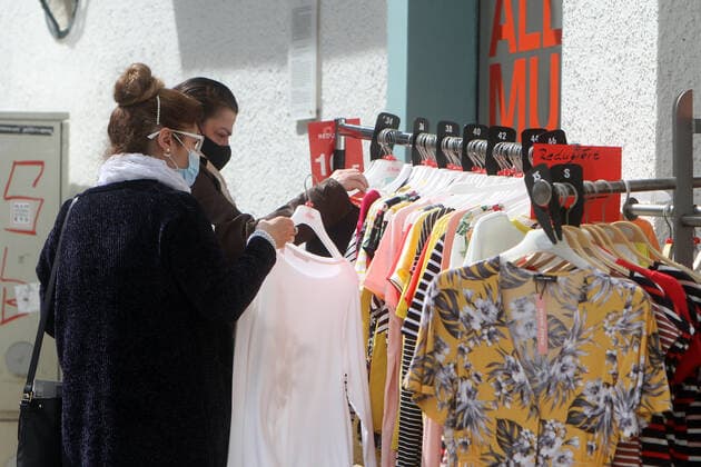Frauen durchstöbern einen Kleiderständer mit Mode an einem geöffneten Geschäft in der Innenstadt von Bad Nauheim, Hessen, Deutschland