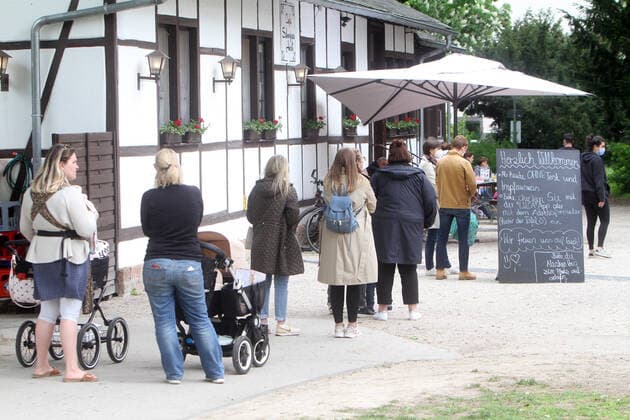 Eine lange Warteschlange von Kunden steht vor dem Außenbereich einer geöffneten Gastätte in Bad Nauheim, Hessen, Deutschland. Der Aufsteller trägt die Aufschrift herzlich willkommen, ab heute ohne Test und Impfausweis. Bitte checken Sie mit der Luca App oder mit dem Adressformular ein.
