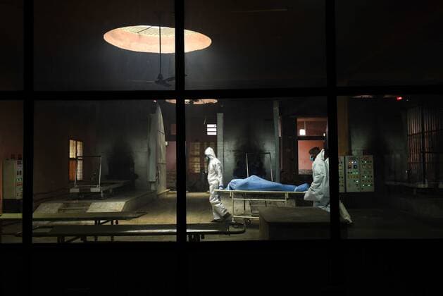 NEW DELHI, INDIA - MAY 21: Health workers take the mortal remains of a Covid-19 victim for cremation, at Nigambodh Ghat crematorium, on May 21, 2021 in New Delhi, India. (Photo by Ajay Aggarwal Hindustan Times) Daily Life Amid Coronavirus Pandemic In India