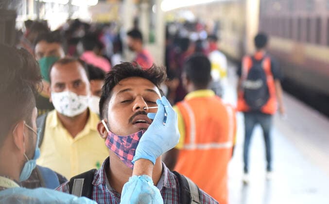 MUMBAI, INDIA - MAY 21: A healthcare worker collects a swab sample for Covid-19 test, at Lokmanya Tilak Terminus, on May 21, 2021 in Mumbai, India. (Photo by Satish Bate Hindustan Times) Medical Team Conducts COVID-19 Coronavirus Test