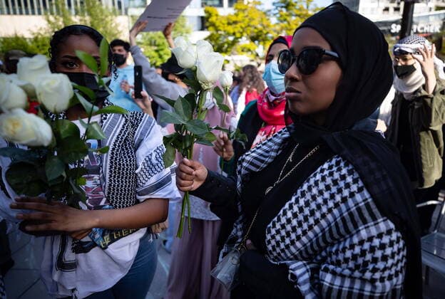 May 22, 2021, Vancouver, BC, Canada: Women hold roses during a vigil in support of the Palestinian people in their conflict with Israel, in Vancouver, on Saturday, May 22, 2021. Vancouver Canada  - ZUMAc35_ 20210522_zaf_c35_130 Copyright: xDarrylxDyckx