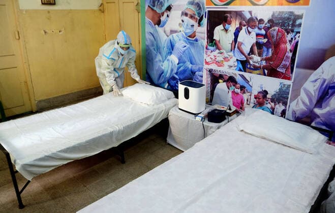(210523) -- KOLKATA, May 23, 2021 -- A health worker makes the bed in a building converted into a care center with oxygen support for COVID-19 patients in Kolkata, India, on May 23, 2021. (Str Xinhua) INDIA-KOLKATA-COVID-19-CARE CENTER Stringer 