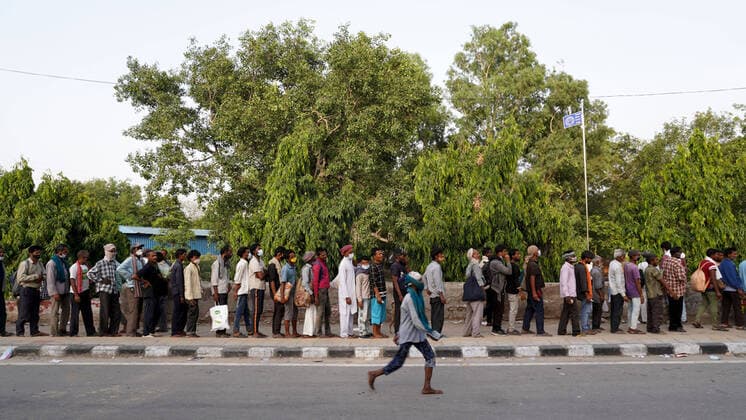 Corona Virus Outbreak In India Homeless people and daily wage labourers, struggling to find work amid lockdown restrictions imposed to curb the spread of Covid-19, queue up to receive food distributed by volunteers along a road on May 23, 2021 in New Delhi, India. New Delhi India makhija-notitle210523_npK6i  Copyright: xMayankxMakhijax