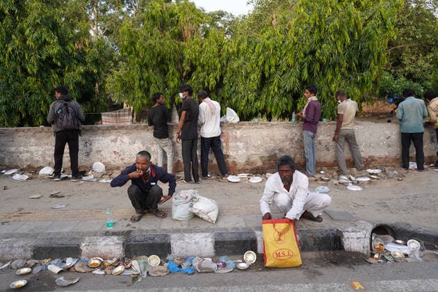 Corona Virus Outbreak In India Homeless people and daily wage labourers, struggling to find work amid lockdown restrictions imposed to curb the spread of Covid-19, eat the food distributed by volunteers along a road on May 23, 2021 in New Delhi, India. New Delhi India makhija-notitle210523_npasg  Copyright: xMayankxMakhijax