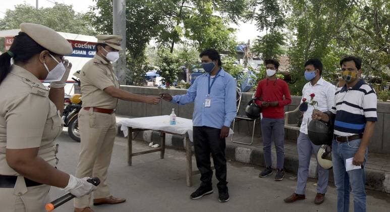 NEW DELHI, INDIA - MAY 23: Delhi police officer offer flowers to people who stepped out of their homes during lockdown and requested them to stay indoor and follow covid guidelines At Geeta colony on May 23, 2021 in New Delhi, India. Police also distributed masks and sanitizers to the violators. Delhi reported 1649 new cases of COVID on May 23.(Photo by Sonu Mehta Hindustan Times) Delhi Police Give Roses To Lockdown Violators